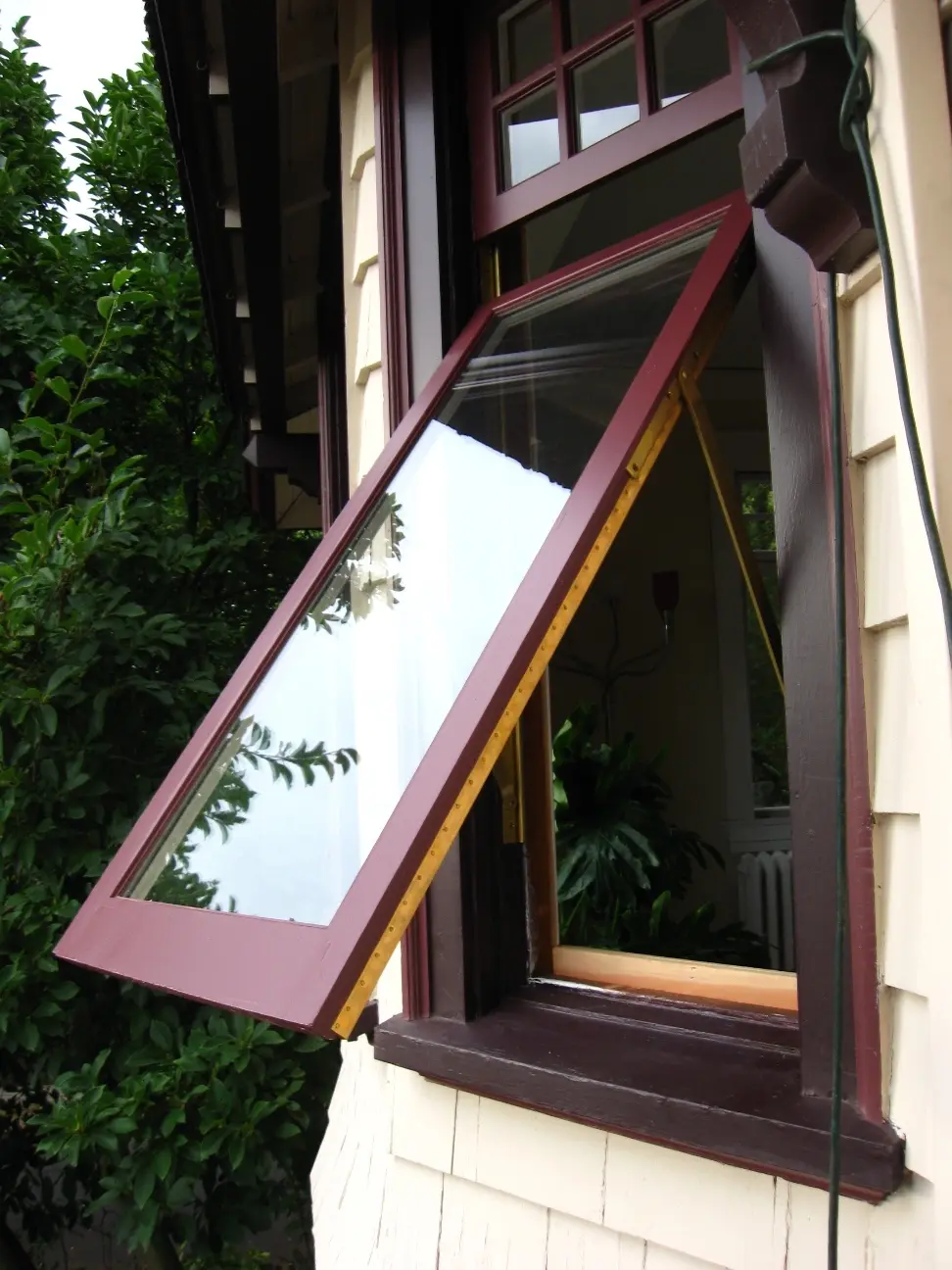 Operable custom wood window shown open on a historic home