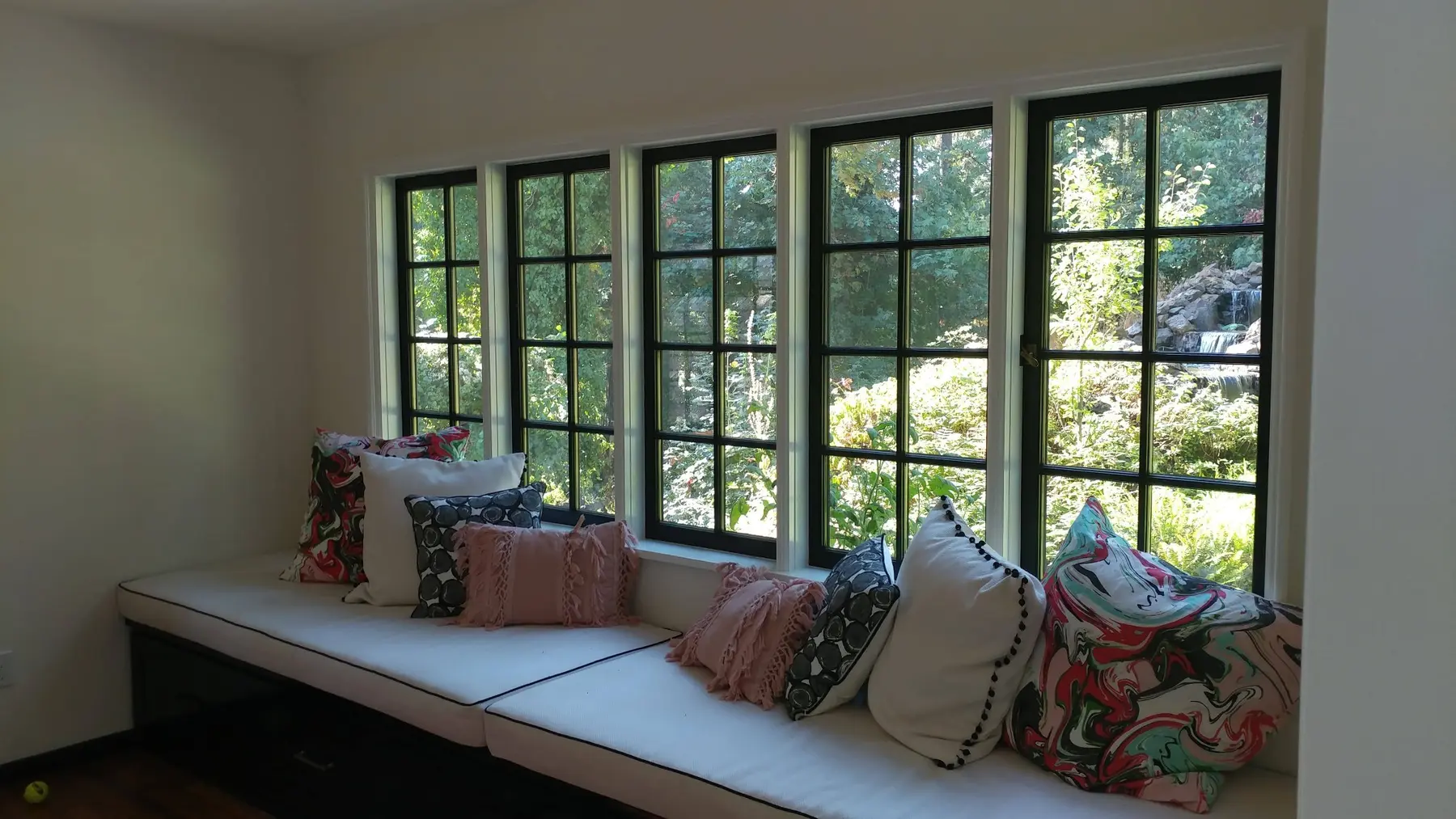Black divided-lite custom wood windows over a built-in window seat