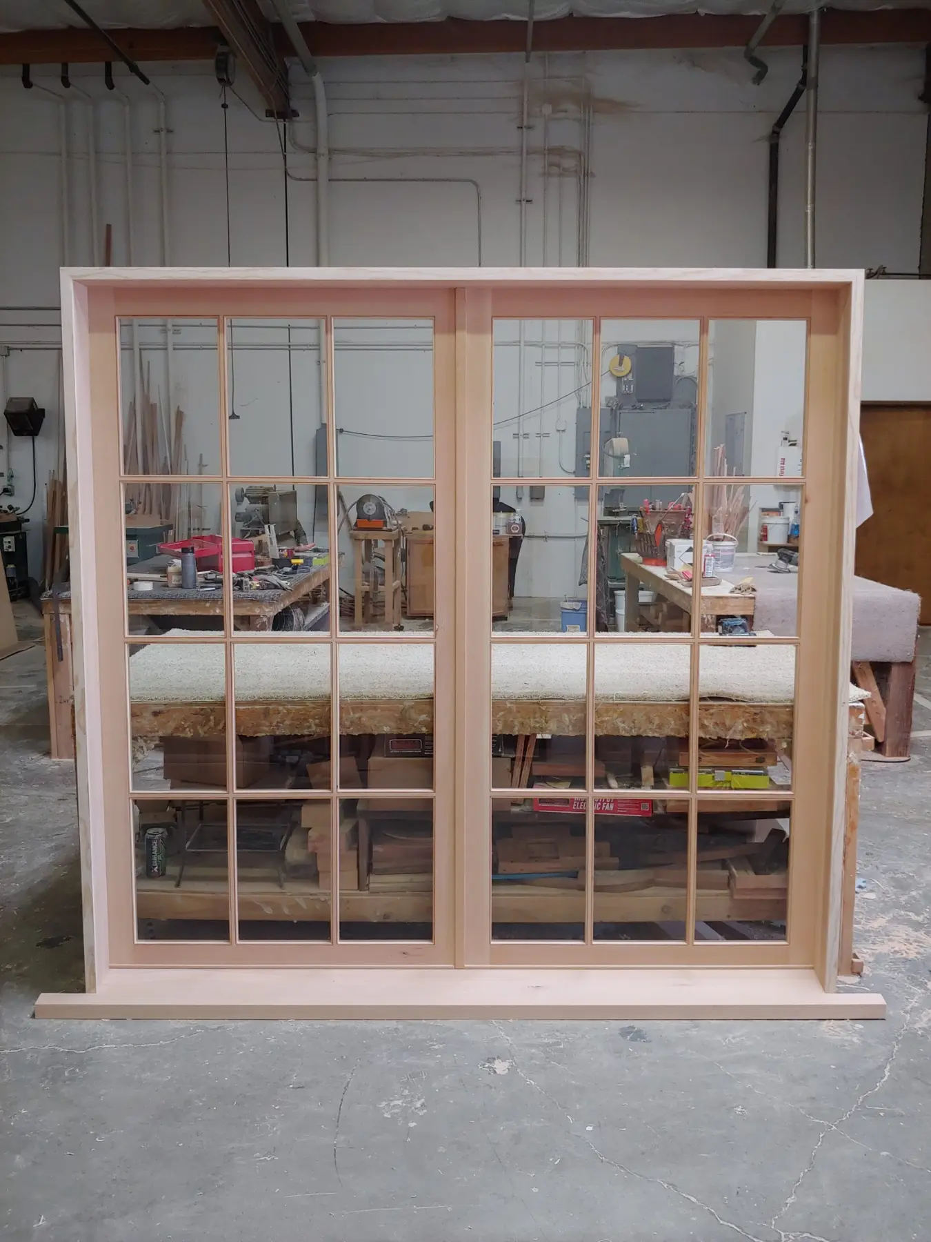 Pair of divided-lite custom wood windows in the Wooddale workshop