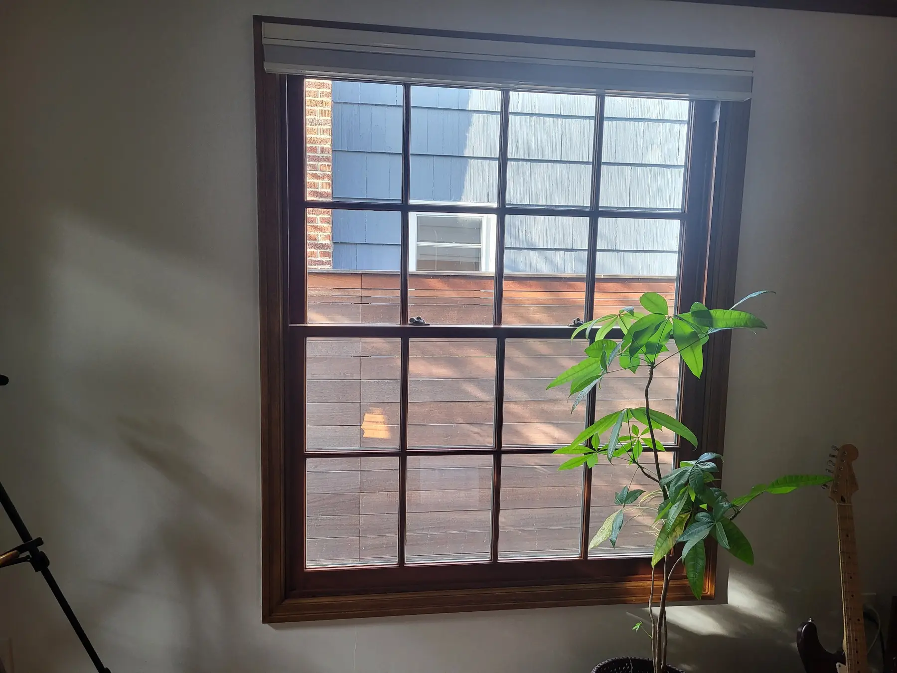 Installed divided-lite wood window with dark-stained trim